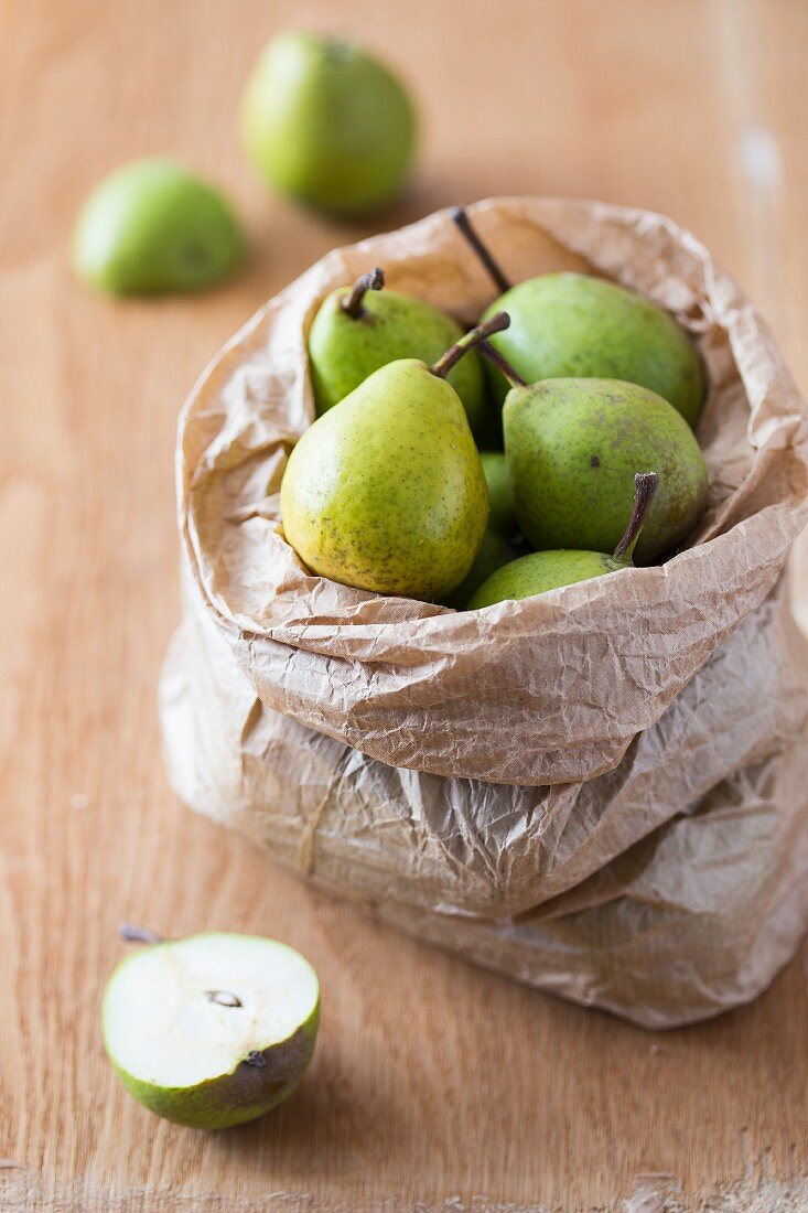 Fresh ripe pears in a paper bag on a wooden surface