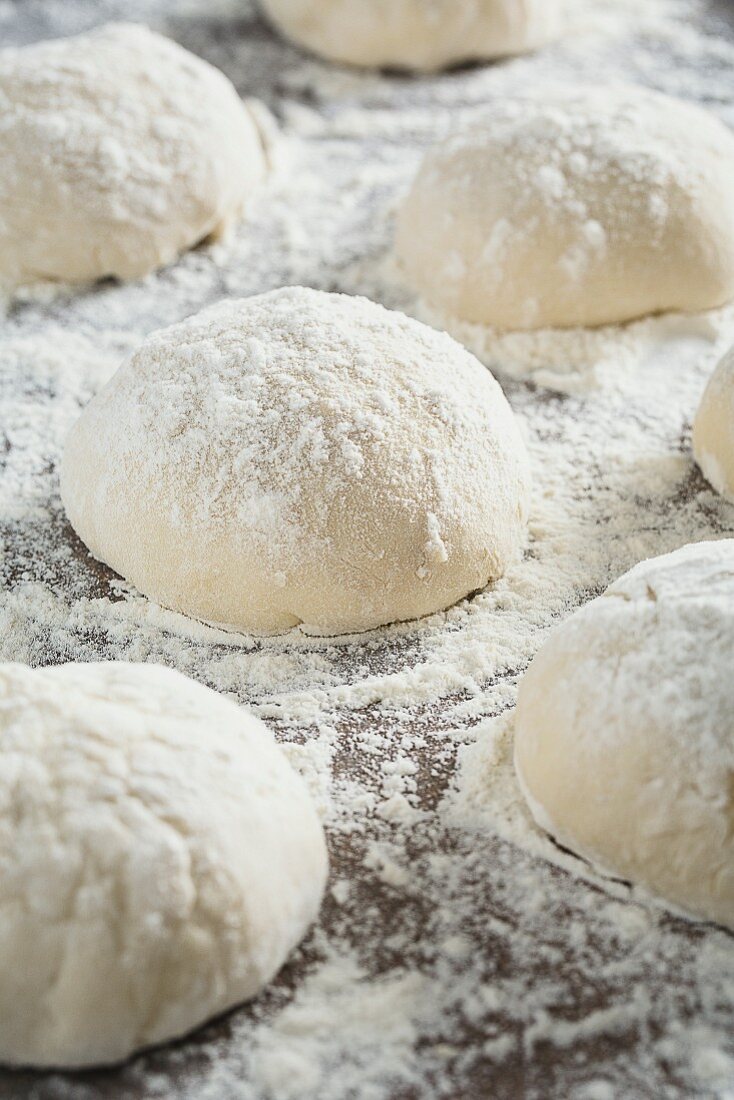 Balls of pizza dough sprinkled with flour