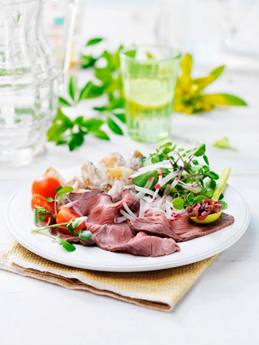 Roast beef with herb salad, tomatoes and potatoes