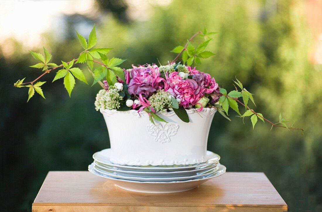 Summer bouquet in white china bowl on table outdoors