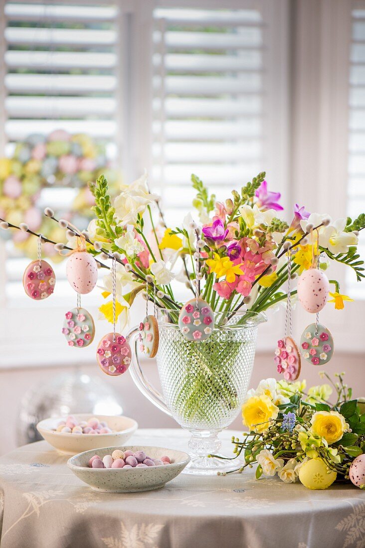 Osterplätzchen hängen auf Frühlingsblumenstrauss