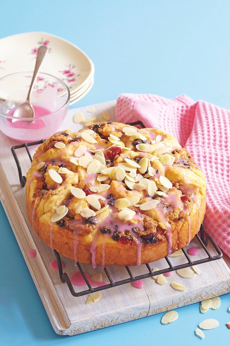 Fruit scones with pink icing and almond flakes