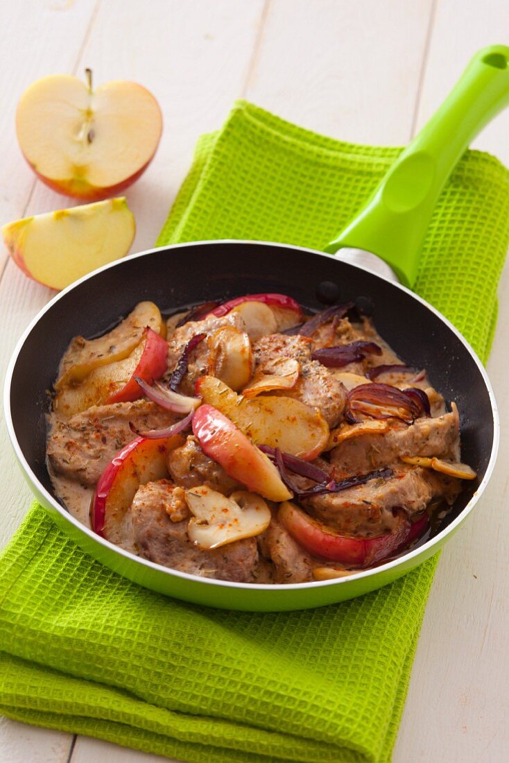 Pork fillet with apple wedges, red onions and mushrooms