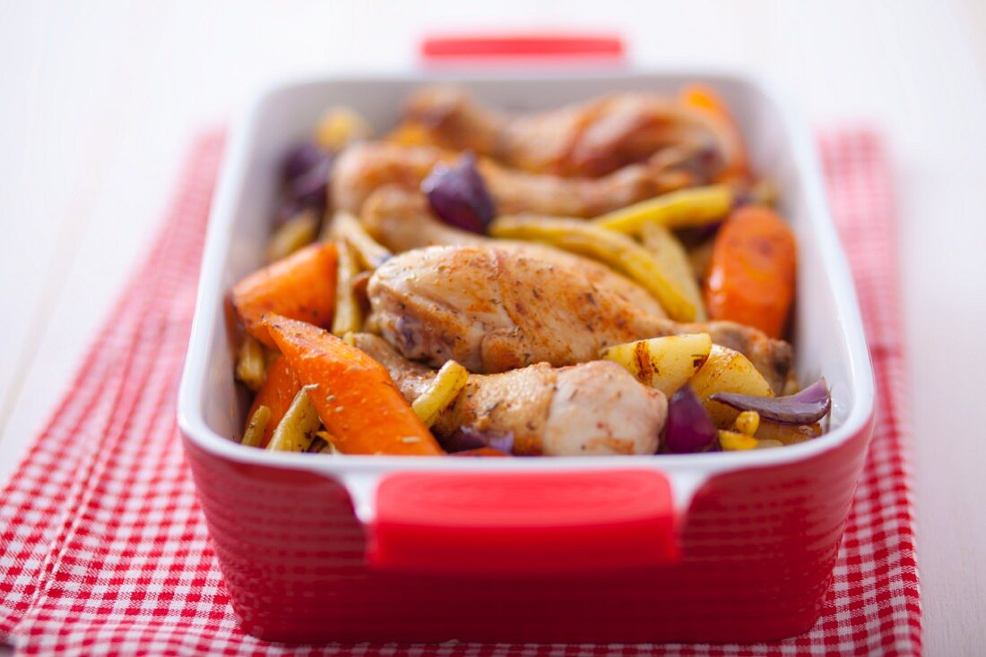 Oven-baked chicken legs with root vegetables and yellow beans