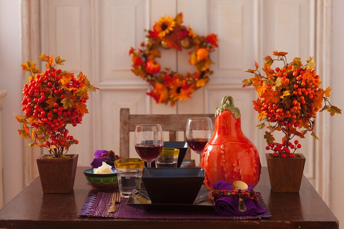 Herbstlich gedeckter Tisch für zwei Personen mit Kürbis- und Beerendeko