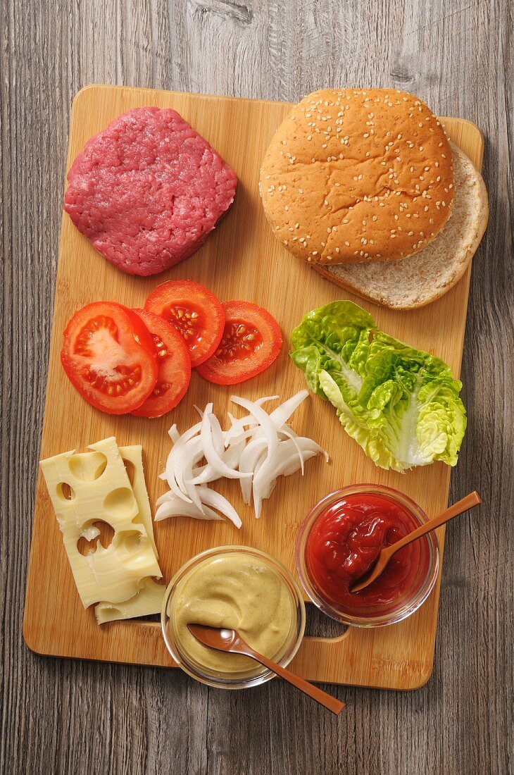 Ingredients for a cheeseburger on a chopping board