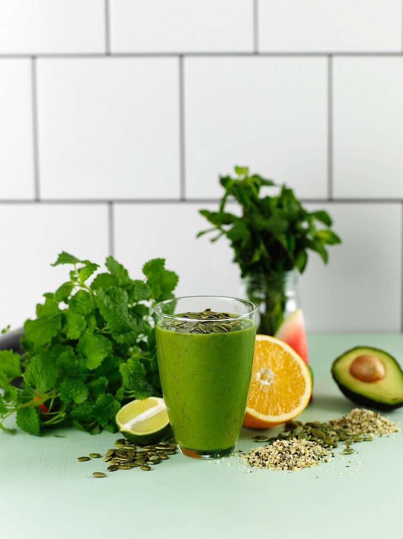 Avocado drink with oranges, herbs and pumpkin seeds