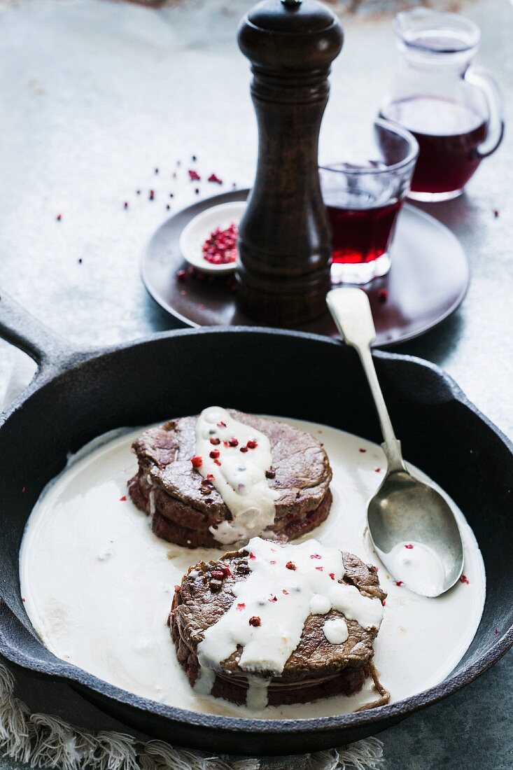 Beef fillet with a creamy sauce and pink peppercorns in a pan