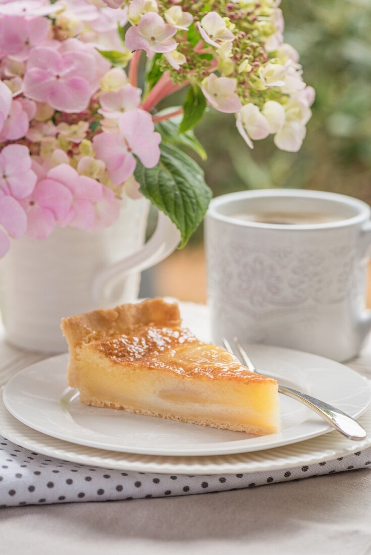 Ein Stück Käsekuchen auf Gartentisch