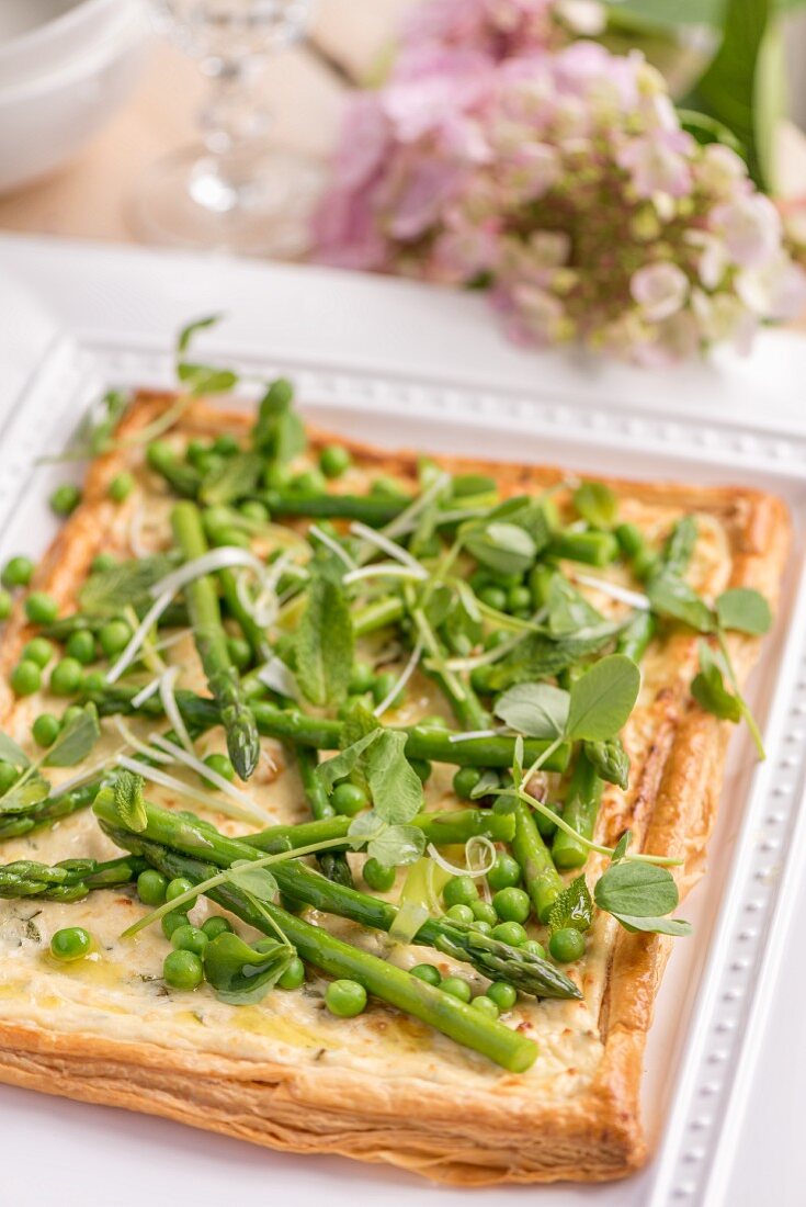 Asparagus tart with peas on a garden table