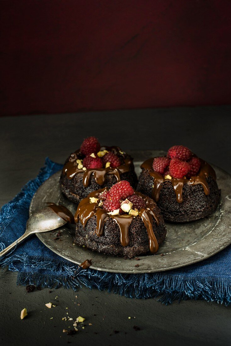 Mini chocolate cakes with chocolate glaze and raspberries