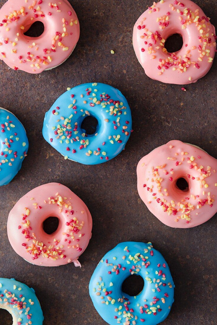 Doughnuts with pink and blue icing and sugar sprinkles