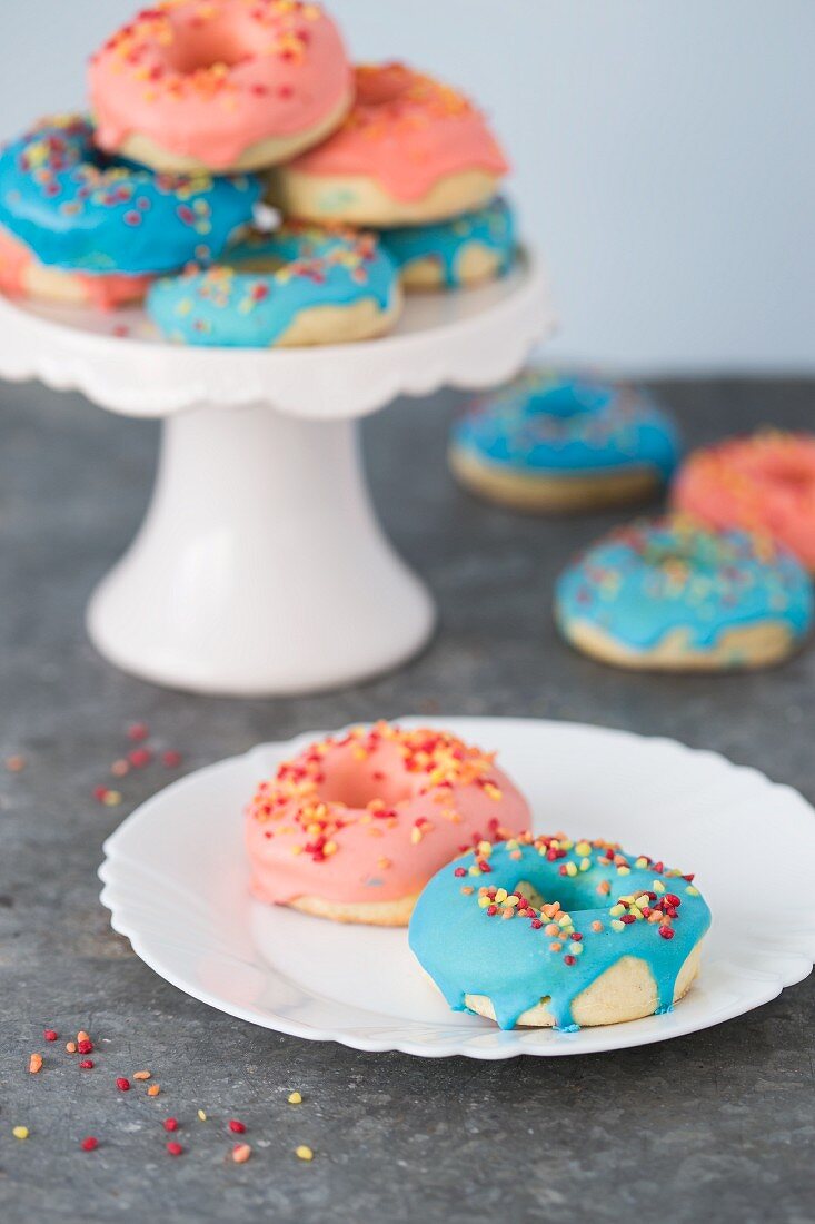 Doughnuts with pink and blue icing and sugar sprinkles