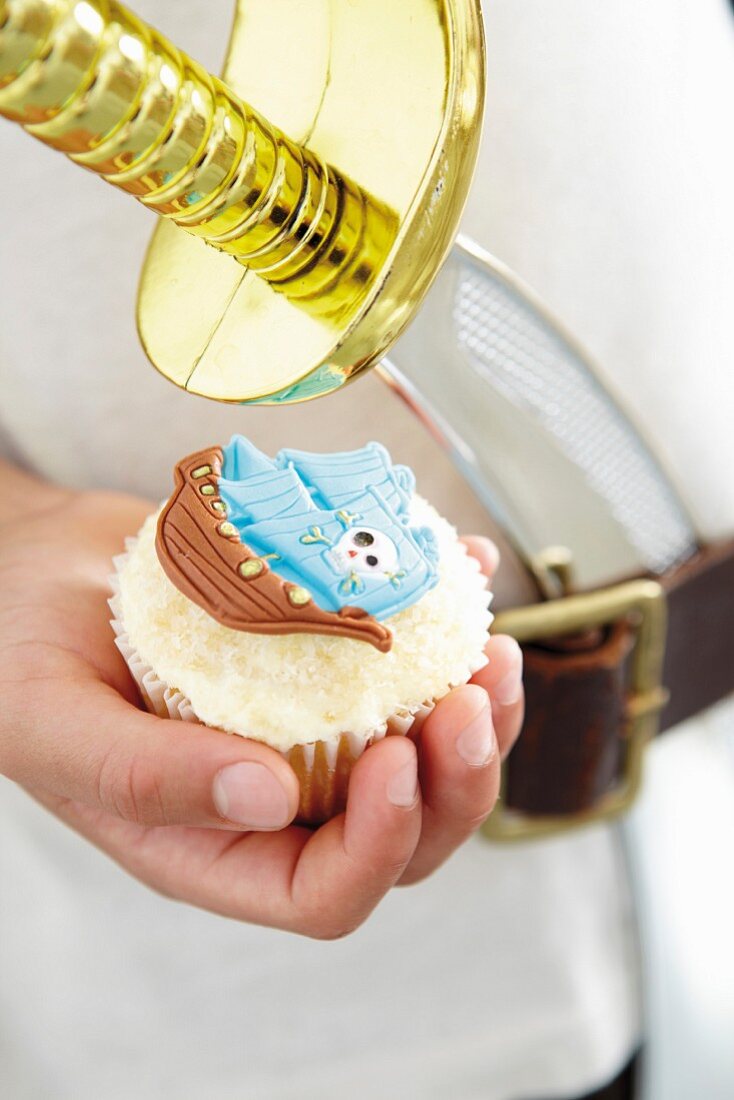 A cupcake with a marzipan pirate decoration