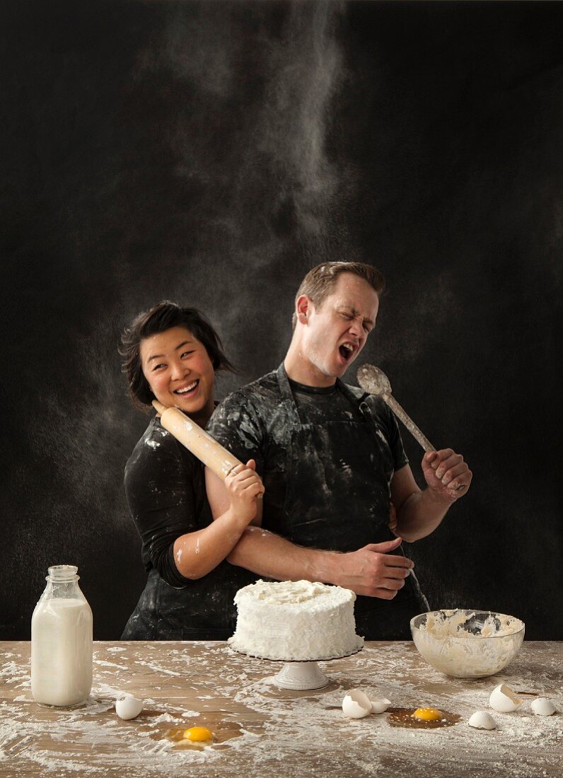 A messy couple baking cake