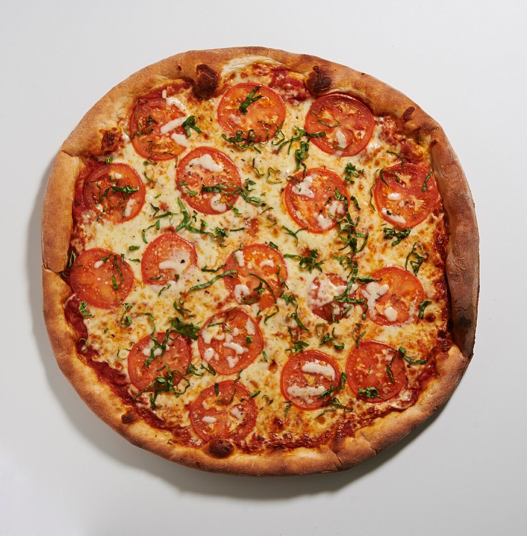 Pizza mit Tomaten und Basilikum (Draufsicht)