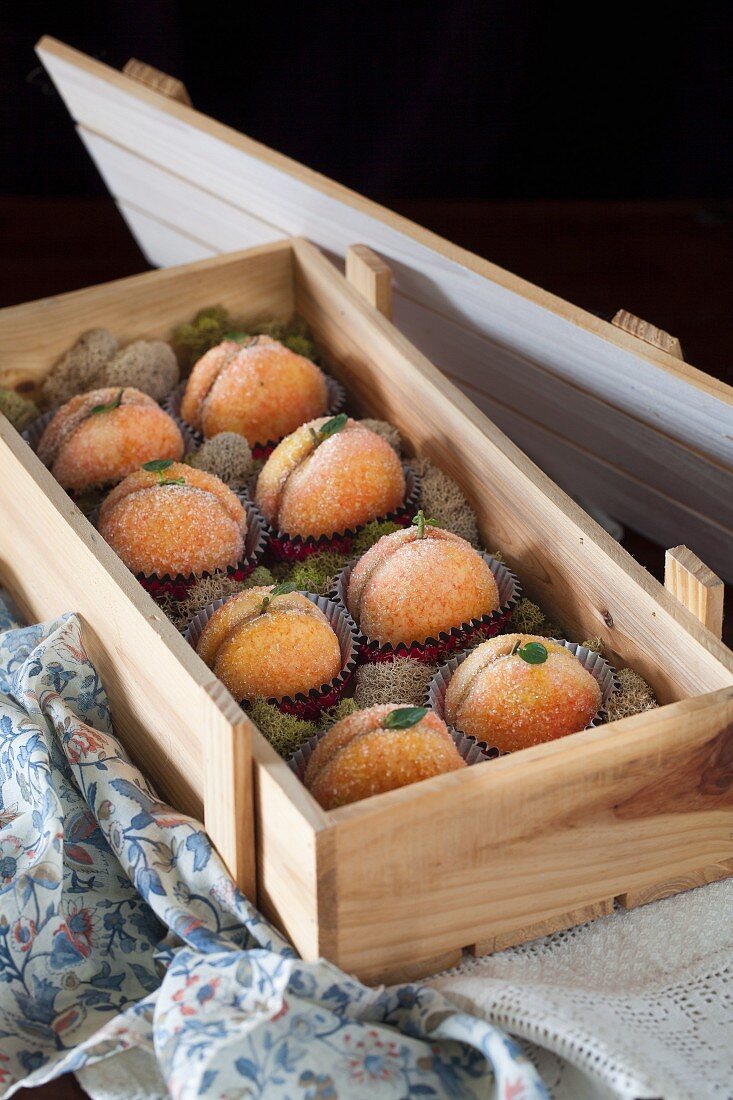 Peach biscuits filled with dulce de leche buttercream in a wooden crate