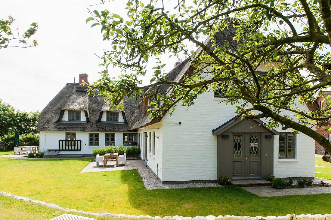 Rustic holiday home with thatched roof in sunny garden