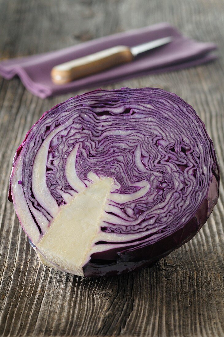 Half a red cabbage on a wooden surface