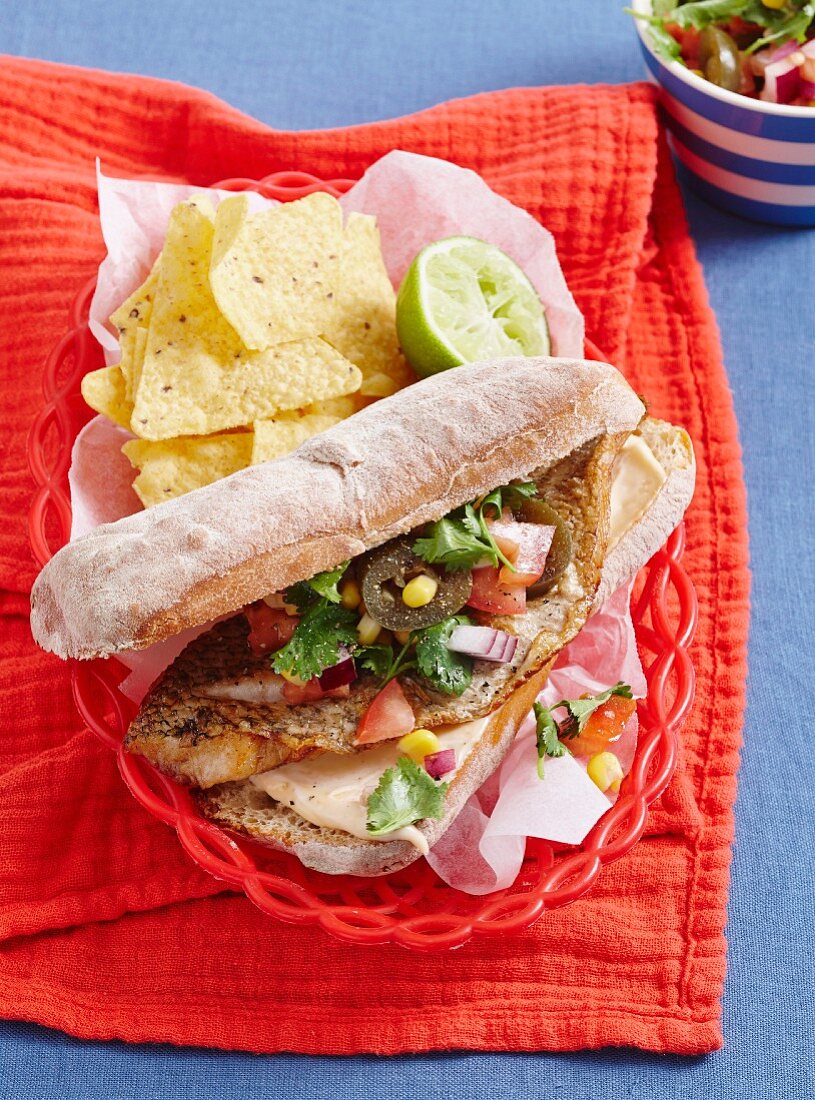 Fish burger with corn chips and salsa