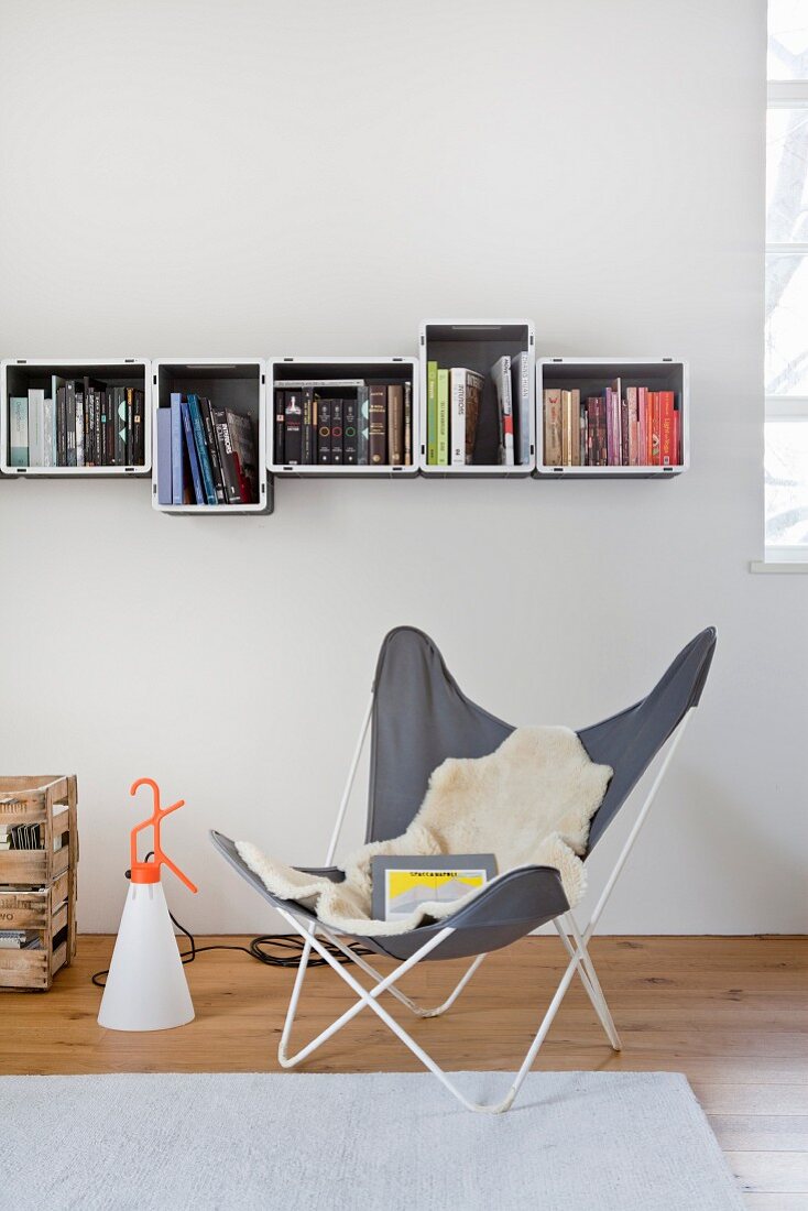 Butterfly chair below bookcase made from plastic crates