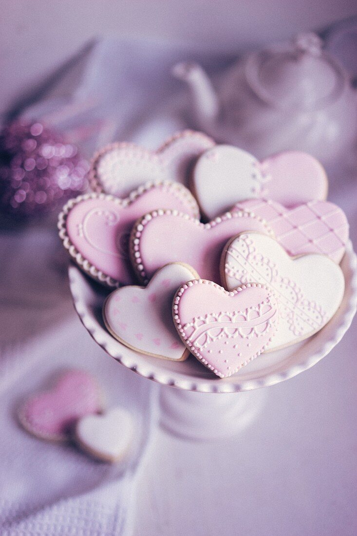 Pastel coloured heart-shaped biscuits on a biscuit stand