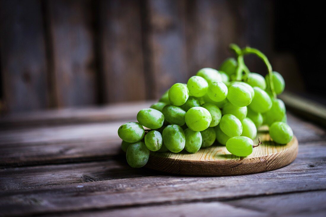 Green grapes on a rustic wooden surface