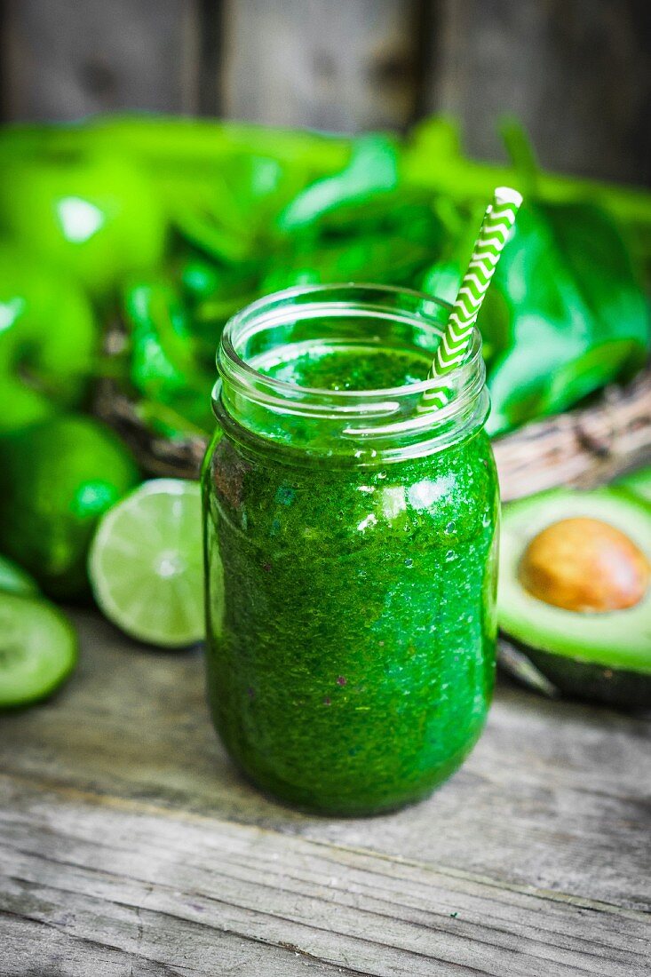 A green smoothie on a rustic wooden surface