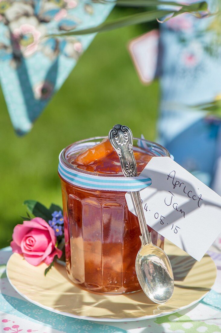 Homemade apricot jam in a jar on a table outside