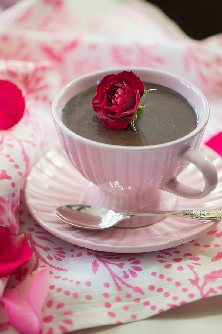 Schokoladenpudding in Tasse garniert mit Rosenblüte