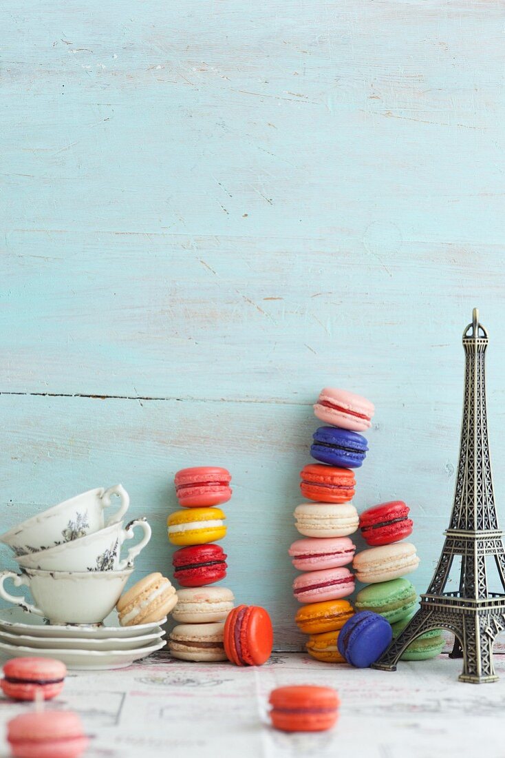 Verschiedene gestapelte Macarons, Teetassen und Eiffelturm