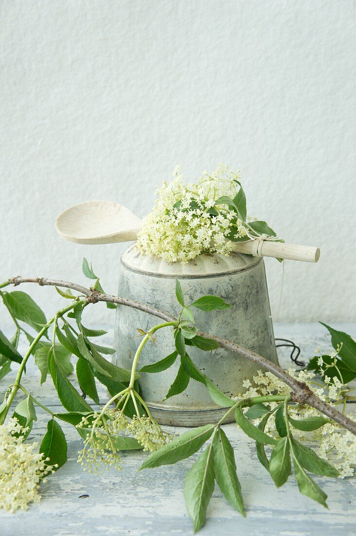 Elderflowers on an old Bundt cake tin with a wooden spoon