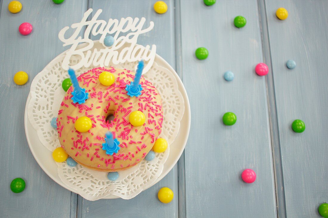 A doughnut with colourful chocolate beans for a birthday