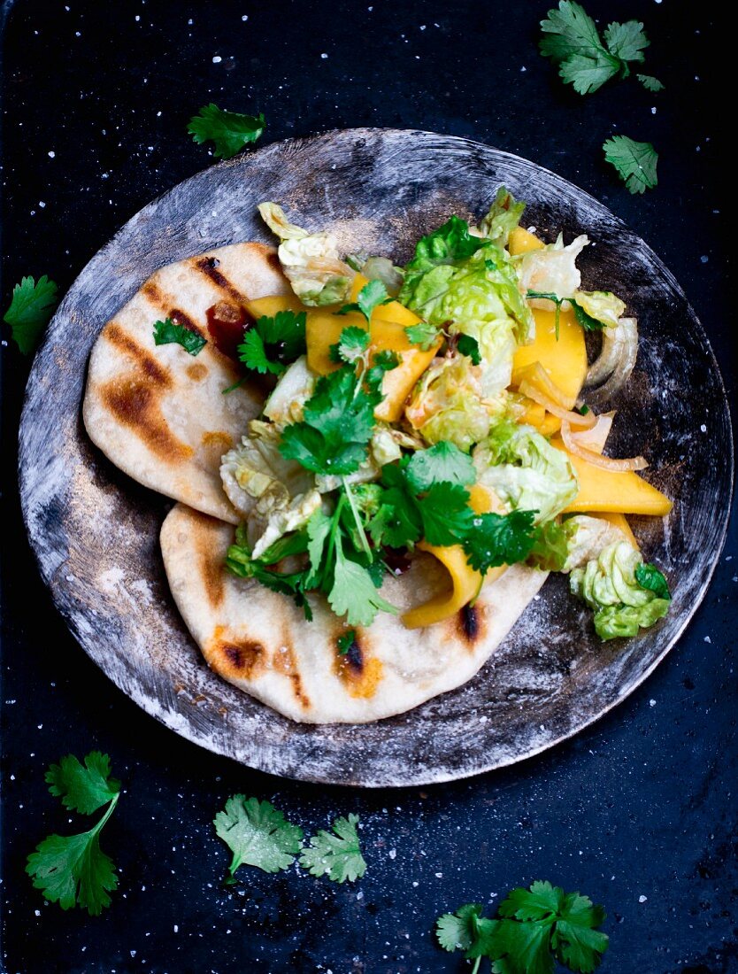 Green salad with mango, coriander and grilled unleavened bread