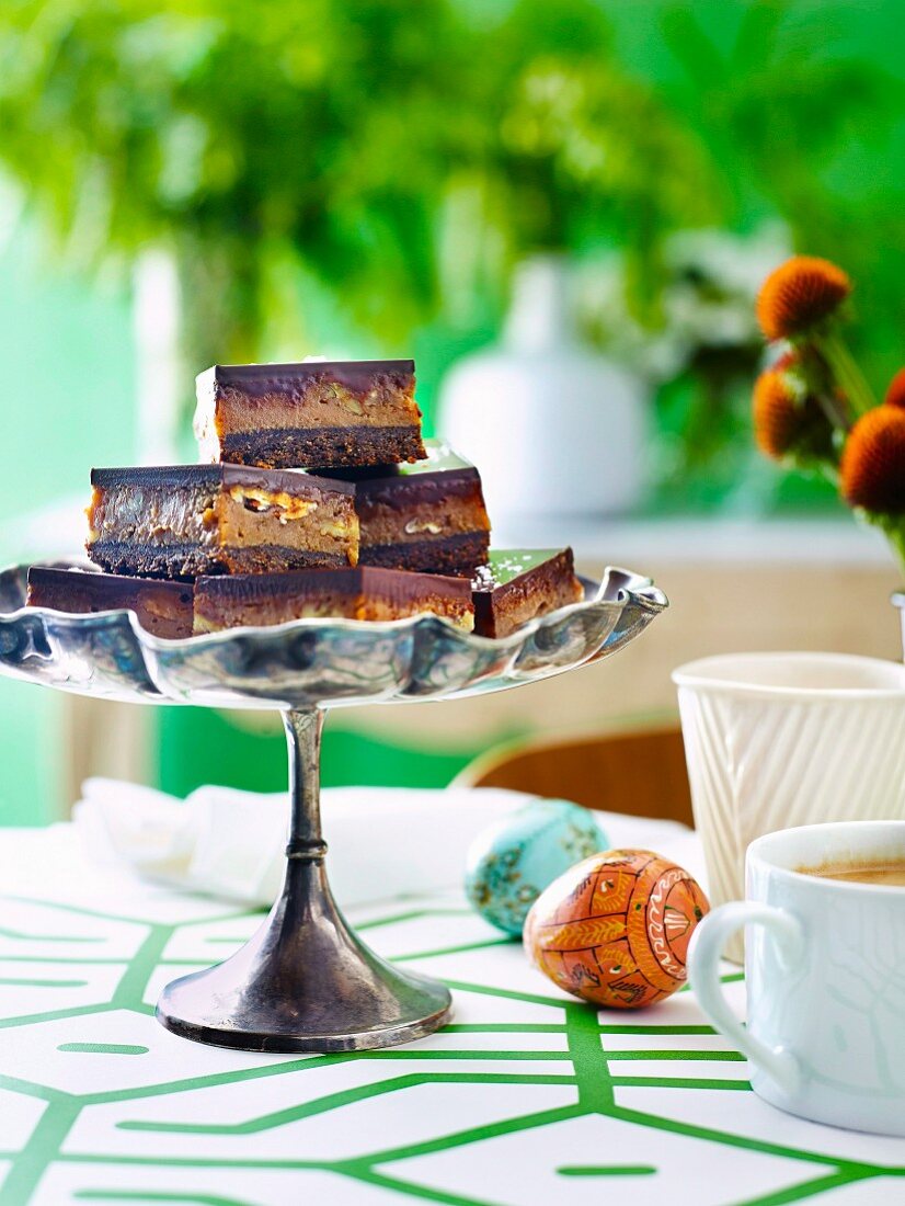 Salted-Caramel-Schokoladen-Schnitten auf Kuchenständer zu Ostern