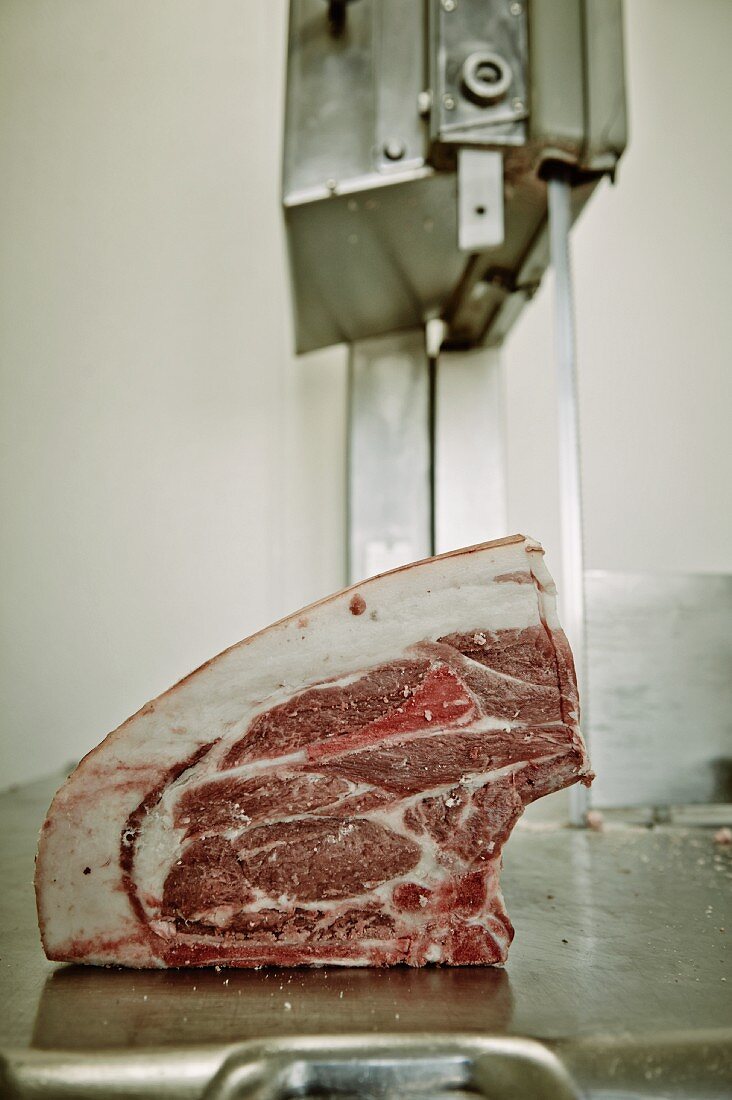 Pork being sliced in a butcher's shop on a meat slicer