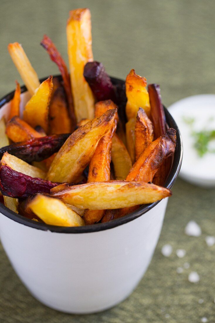 Winter vegetable chips in a cup next to a herb quark dip