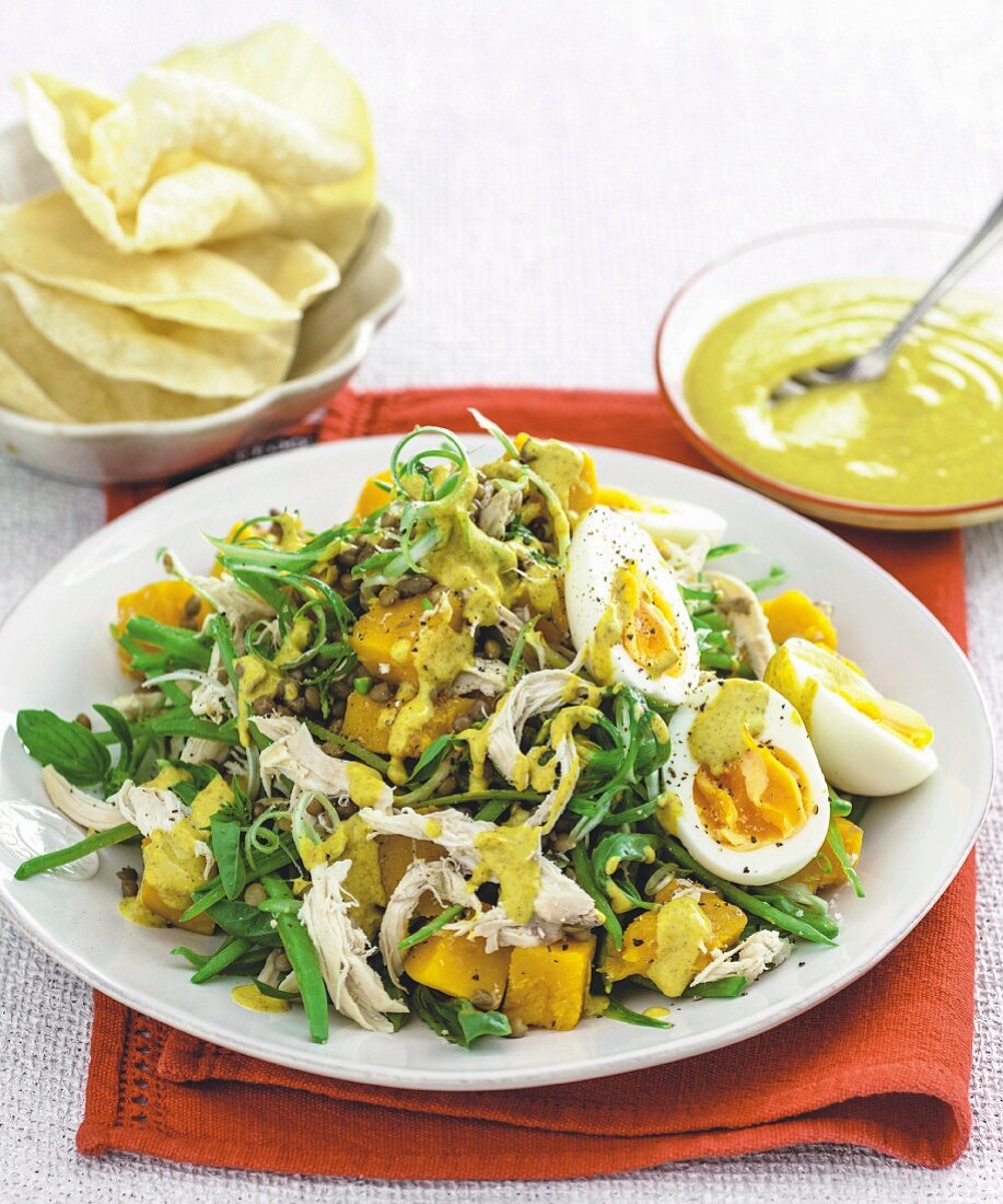 Salat mit Huhn, Kürbis, Linsen, Eiern und Currysauce dazu Papadams