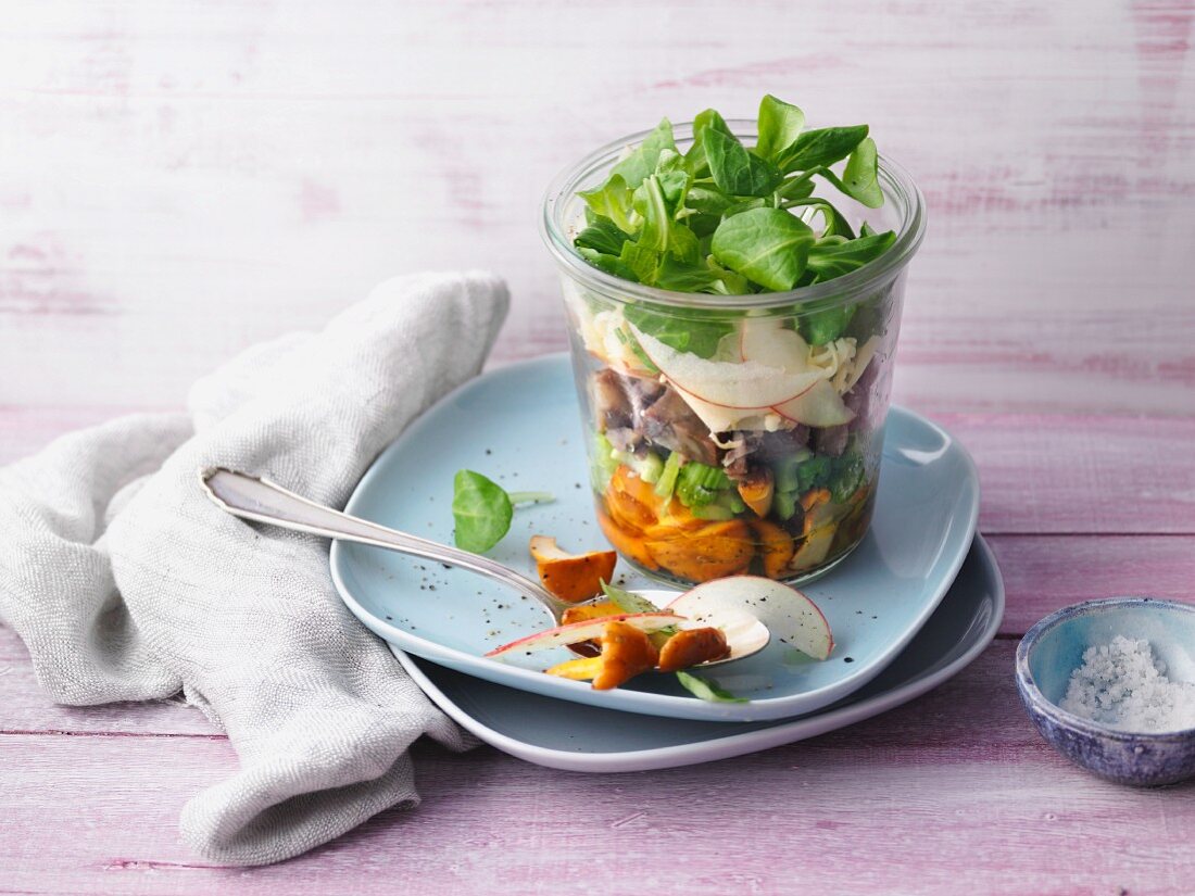 A layered chanterelle mushroom salad with chestnuts in a glass