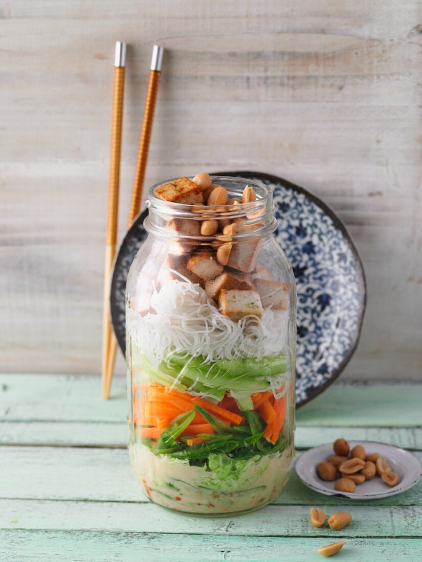 A layered oriental vegetable salad with tofu in a jar