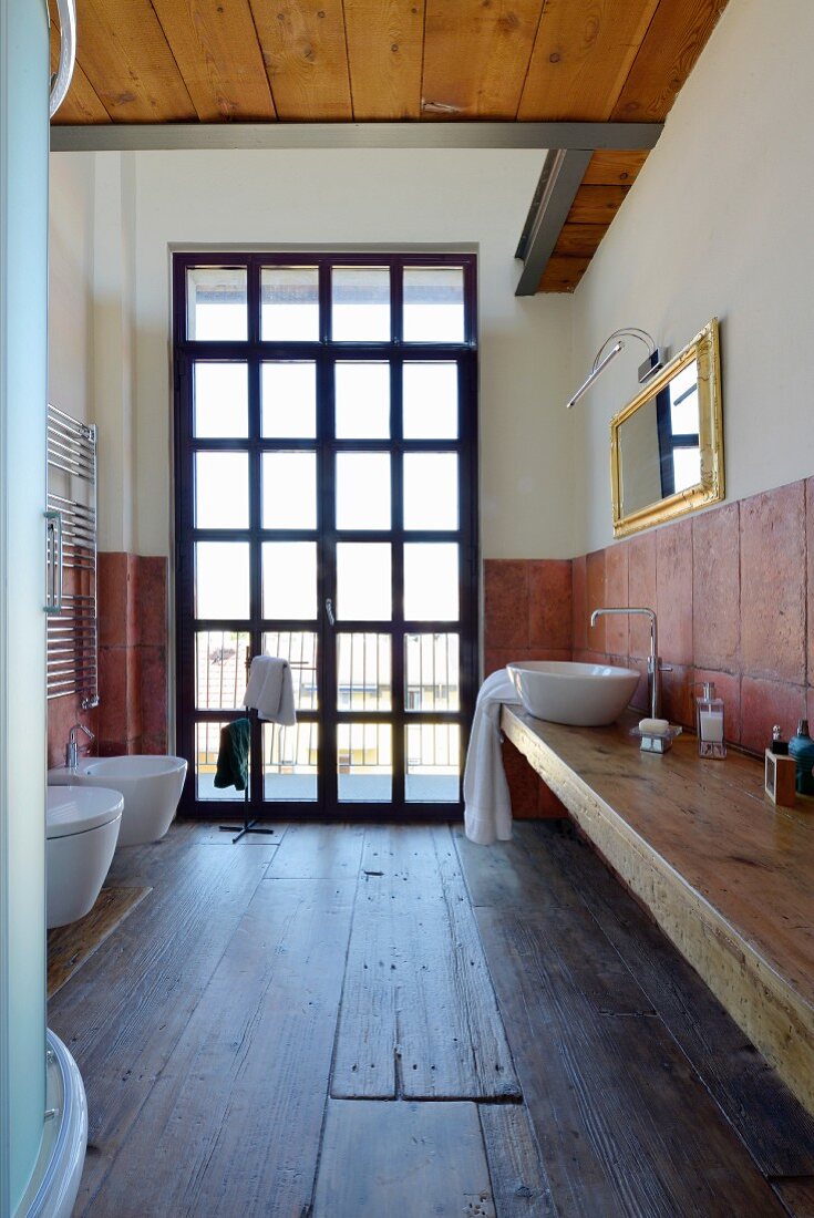 Old wooden floor and lattice window in rustic bathroom