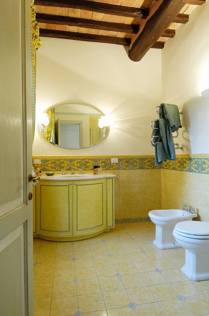 Klassisches Badezimmer mit gelben Fliesen und Holzdecke