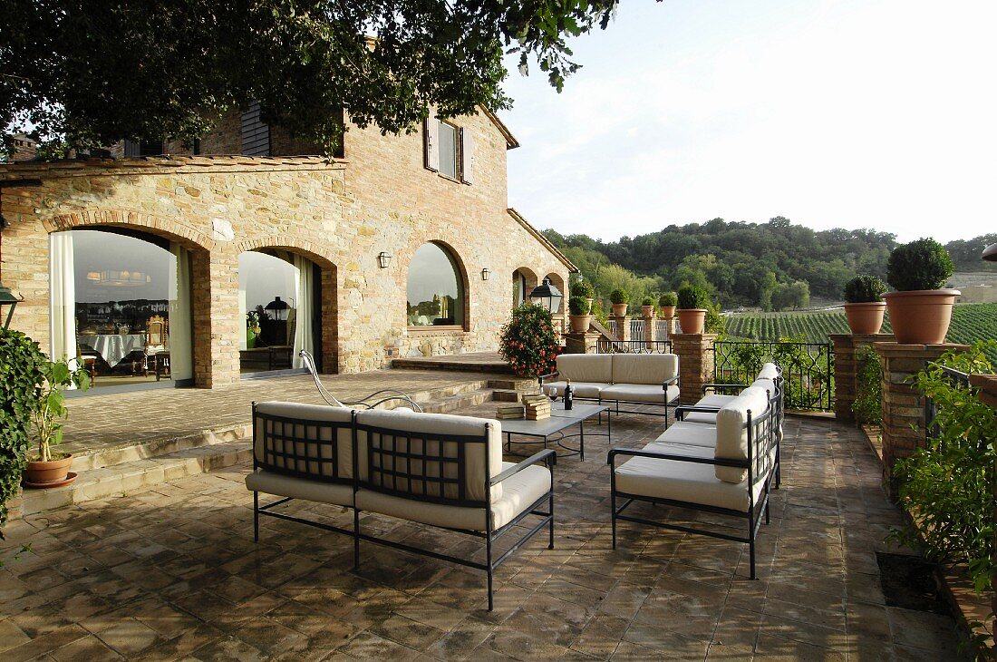 Metal furniture on Mediterranean terrace outside stone house