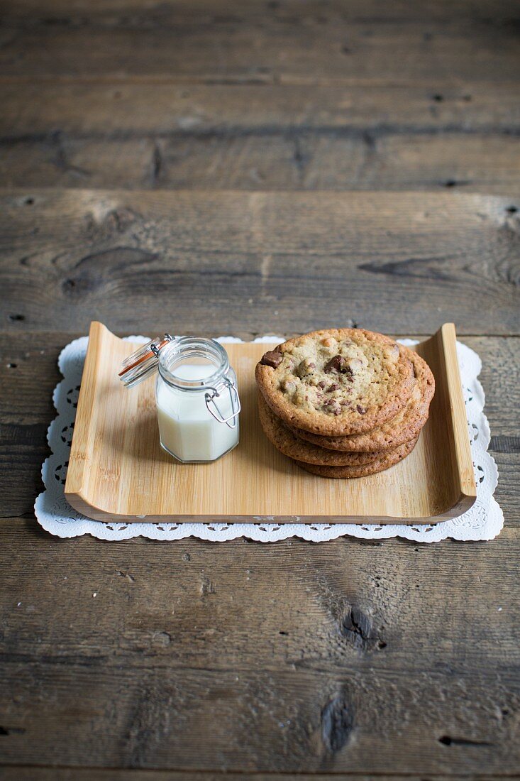 Chocolate chip cookies and milk on a wooden tray