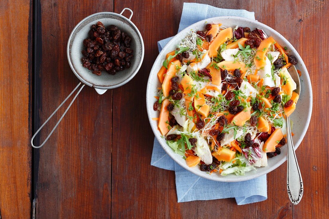 Ppapaya and baked chicken salad with raisins, beansprouts and carrots