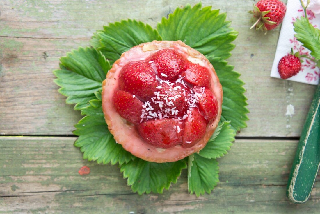 A strawberry tart with coconut sprinkles (seen from above)