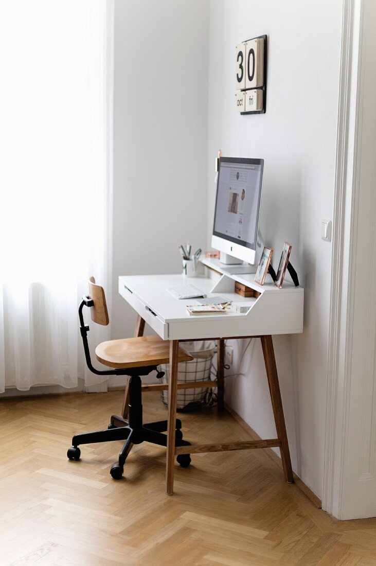 Computer on modern desk and vintage chair