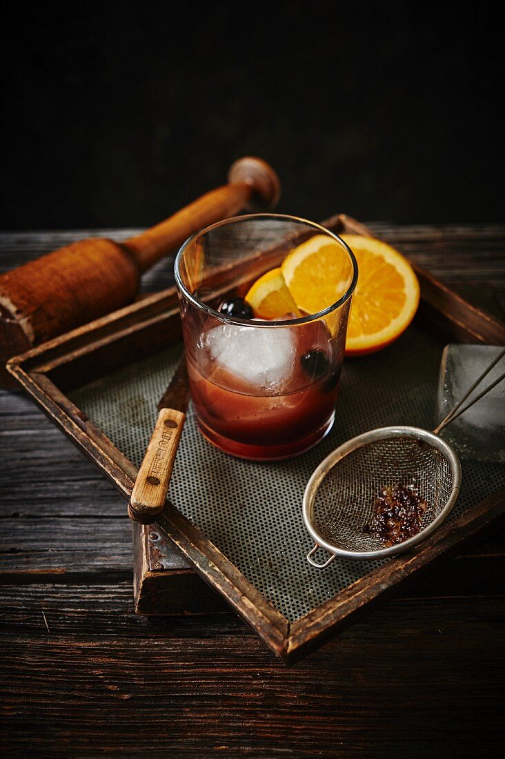 Old fashioned Cocktail mit Orangen und Kirschen
