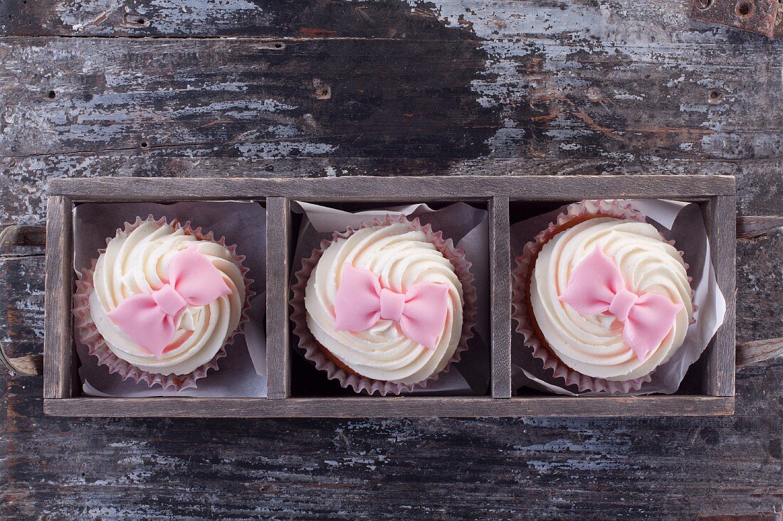 Cupcakes decorated with pink fondant bows (seen from above)