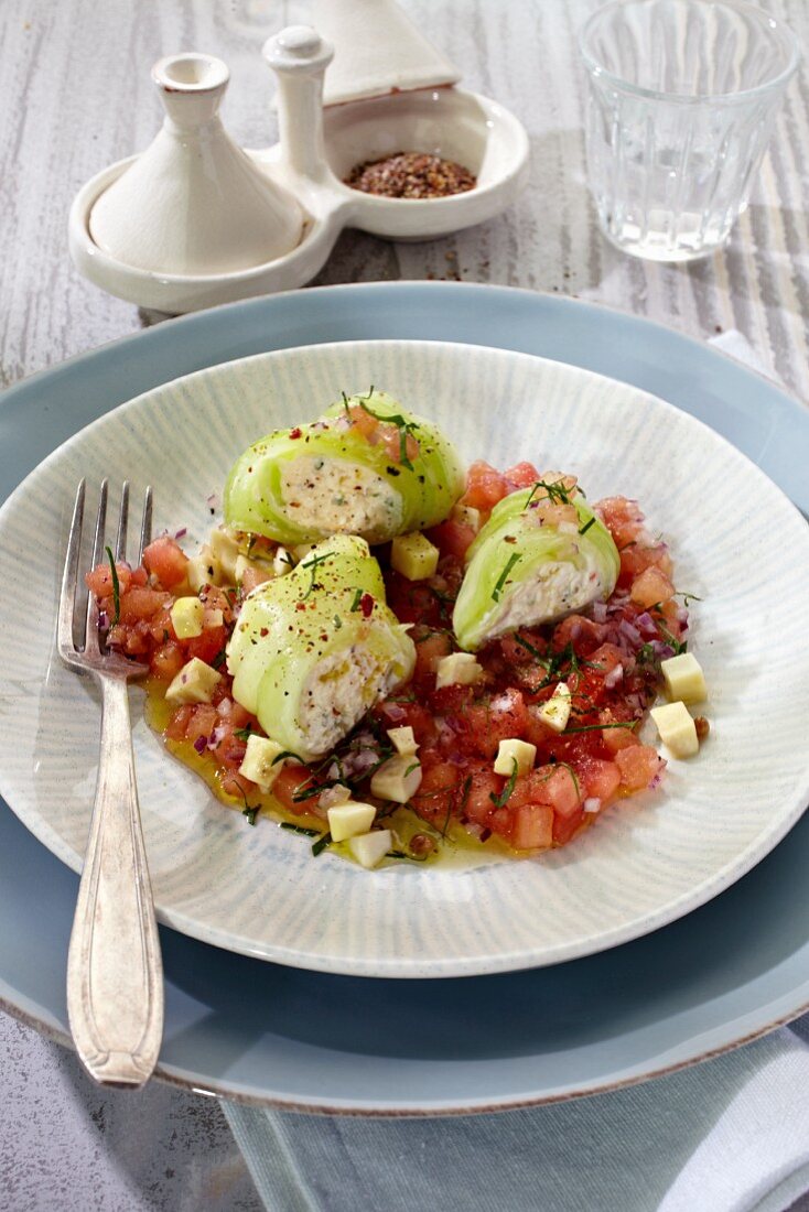 Cucumber rolls with feta cheese on a tomato medley